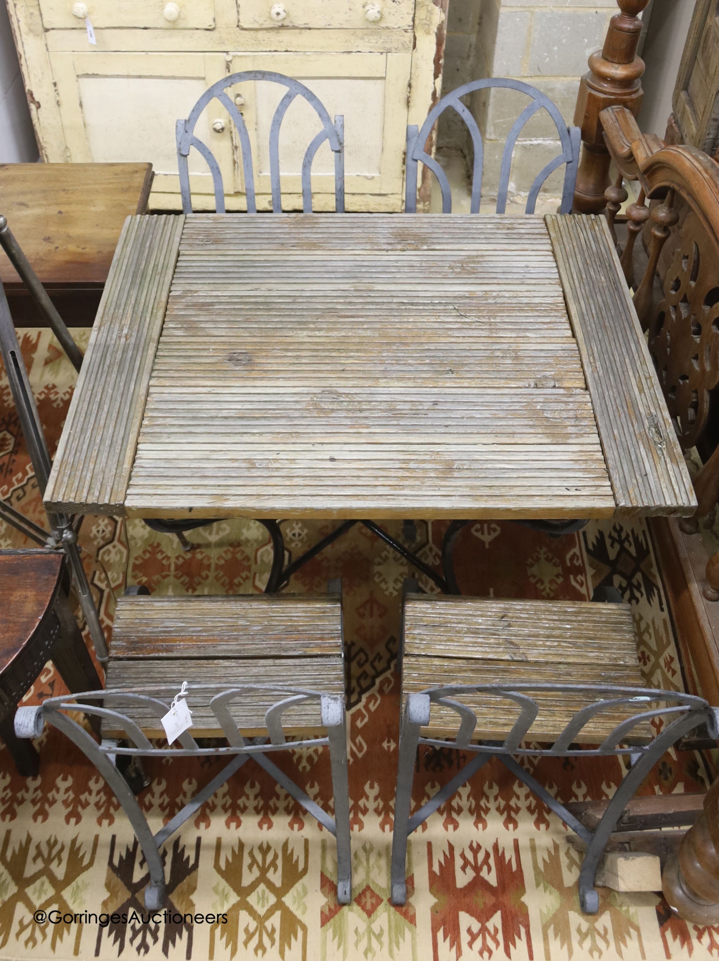 A French slatted wood wrought iron garden table, width 72cm, depth 94cm, height 78cm and four chairs